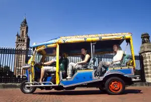 Tuk-Tuk mit Gästen vor dem Friedenspalast in Den Haag