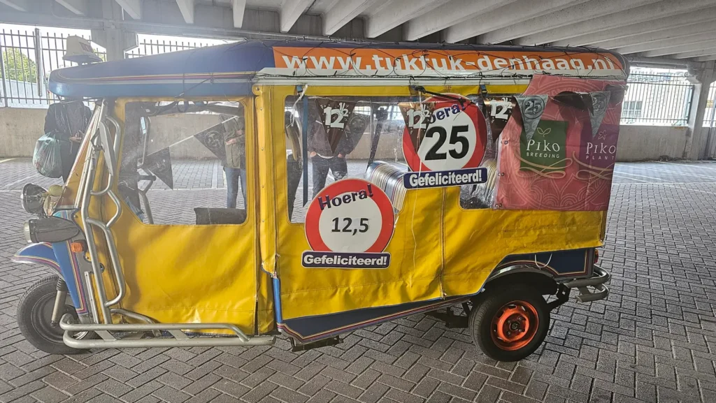 Yellow tuk tuk with an anniversary sign for 12.5 and 25 years of marriage