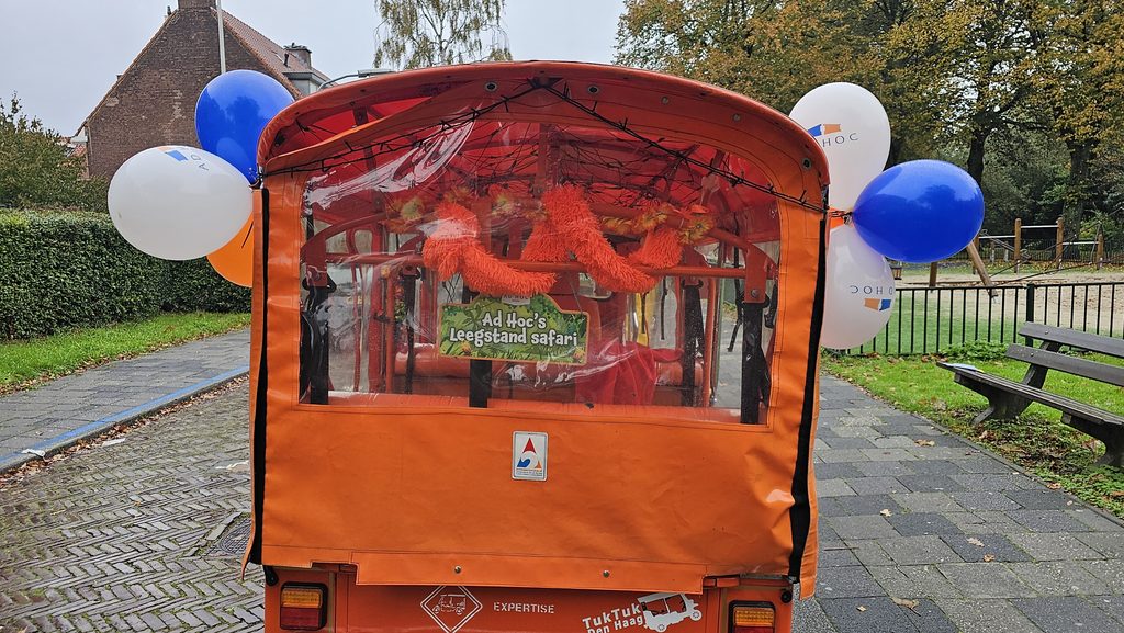 Oranje tuktuk met ballonnen versierd voor een feest