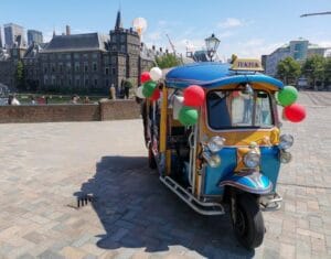 Colourful tuk tuk with balloons at the Binnenhof in The Hague, ready for a party