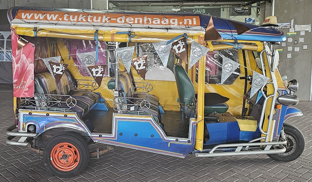 Tuk tuk decorated with 12.5 and 25 year anniversary flags