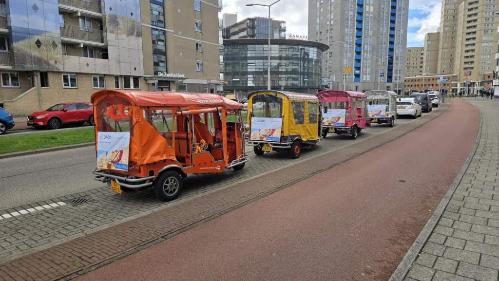 Reihe von Tuk-Tuks mit Werbebannern an der Straße in Den Haag