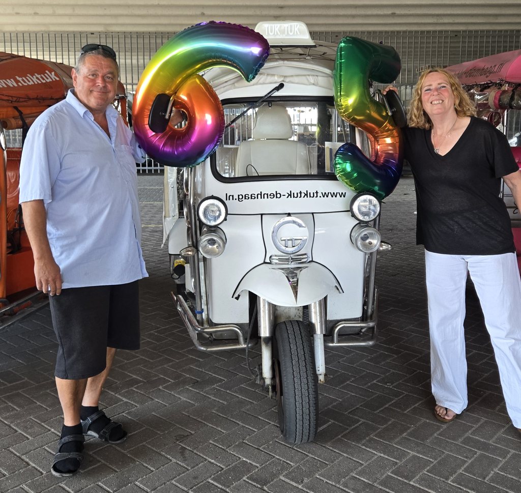 Verjaardag in Den Haag: 65-jarige met folieballonnen bij de witte tuktuk